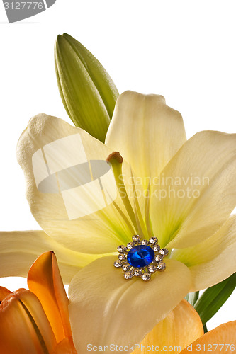 Image of Lilies and a brooch with blue gem