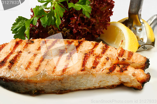 Image of Grilled salmon steak with salad and lemon