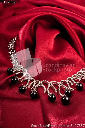 Image of Black pearls on red textile