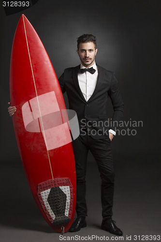 Image of Latino young man with a surf board