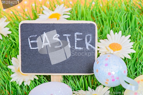 Image of Easter eggs with blackboard on the grass