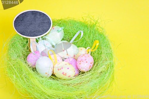Image of Ester eggs in green nest with copy-space board