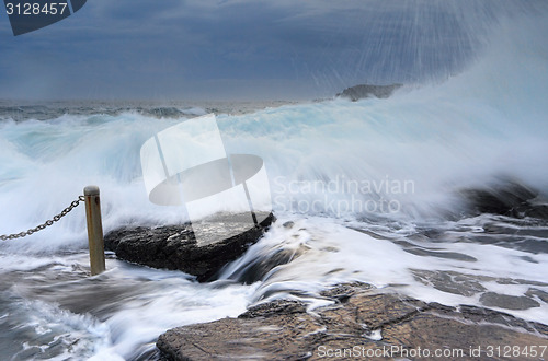 Image of Bracing as powerful waves come crashing over rocks