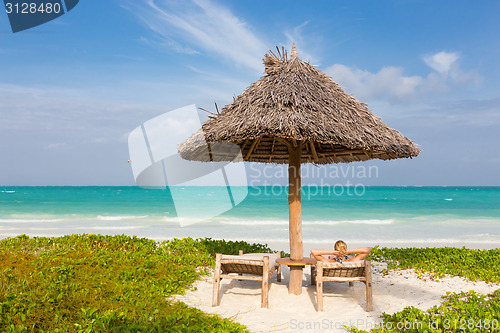 Image of Woman sunbathing on tropical beach.