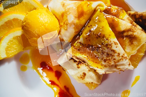 Image of stuffed pancakes with orange syrup and ice-cream