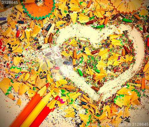 Image of heart, three pencils and colored wooden shavings