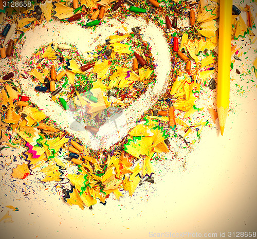 Image of heart, yellow pencil and wooden chips