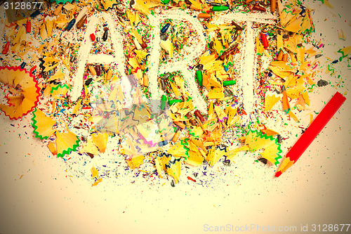 Image of ART word on the background of colored pencil shavings