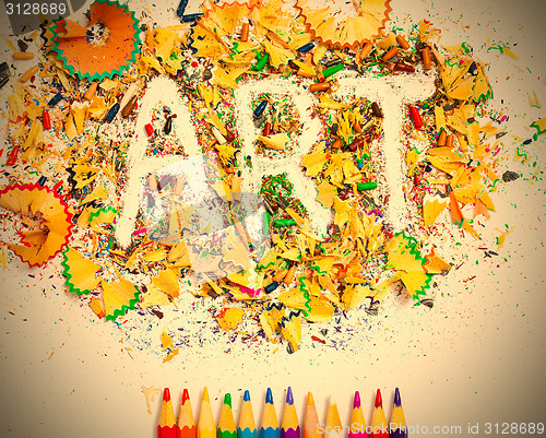 Image of ART word on the background of colored shavings and pencils