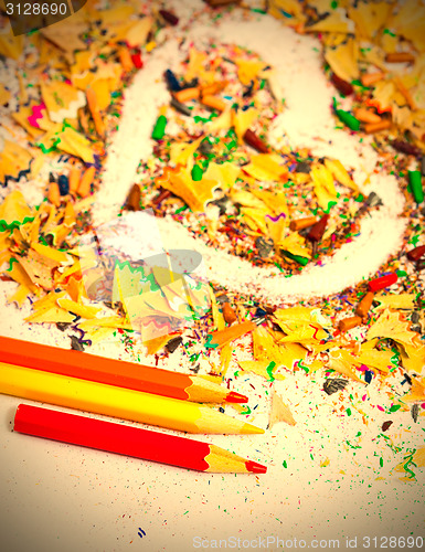 Image of heart, three pencils and colored wooden shavings