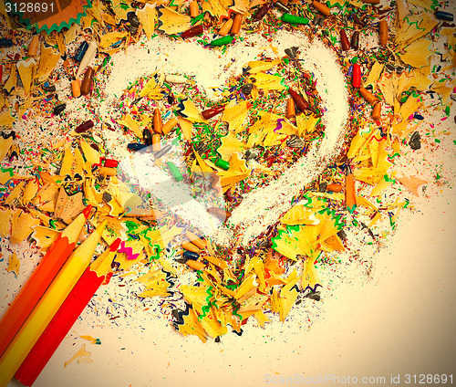 Image of heart, multicolored pencils and varicolored wooden shavings