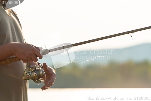 Image of Modern clean fishing rod in hands