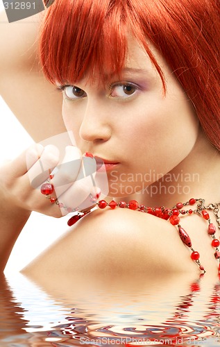 Image of redhead with red beads looking over shoulder in water