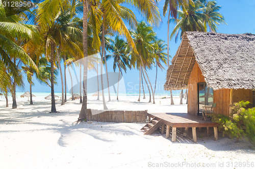 Image of Wooden bungalow on tropical white sandy beach. 