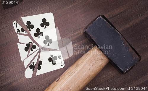 Image of Hammer with a broken card, seven of clubs