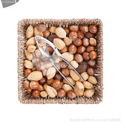 Image of Mixed nuts in a woven basket with nut cracker