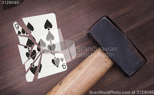 Image of Hammer with a broken card, nine of spades