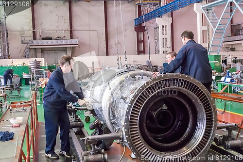 Image of Workers assemble turbine of aviation engine