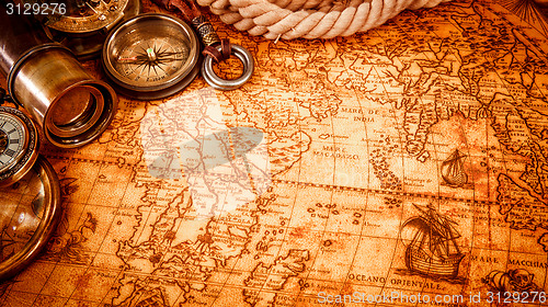 Image of Vintage magnifying glass lies on an ancient world map