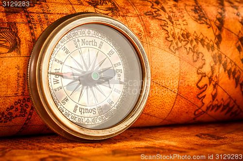 Image of Vintage compass lies on an ancient world map.