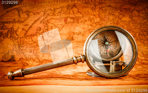 Image of Vintage magnifying glass lies on an ancient world map