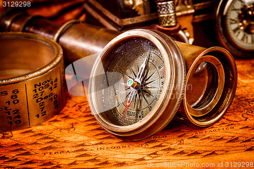 Image of Vintage compass lies on an ancient world map.