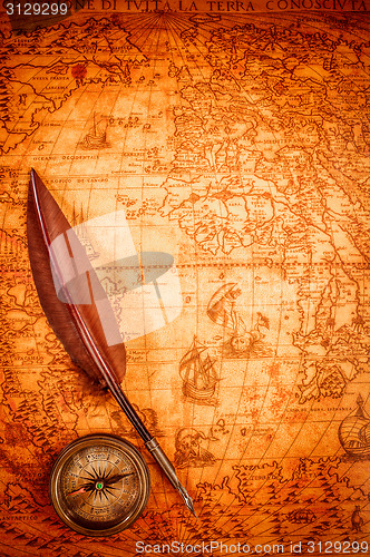 Image of Vintage magnifying glass lies on an ancient world map