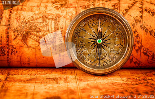 Image of Vintage compass lies on an ancient world map.