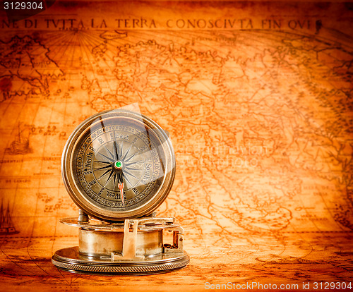 Image of Vintage compass lies on an ancient world map.