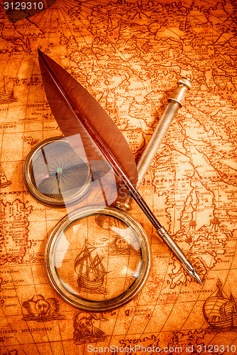 Image of Vintage magnifying glass lies on an ancient world map