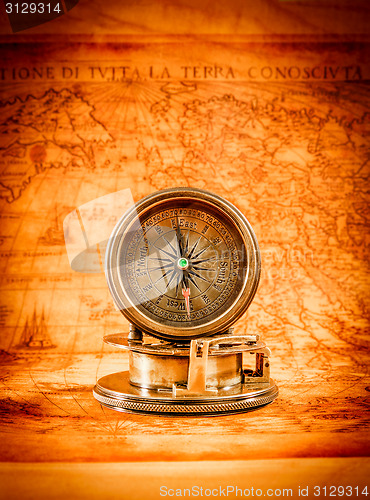 Image of Vintage compass lies on an ancient world map.