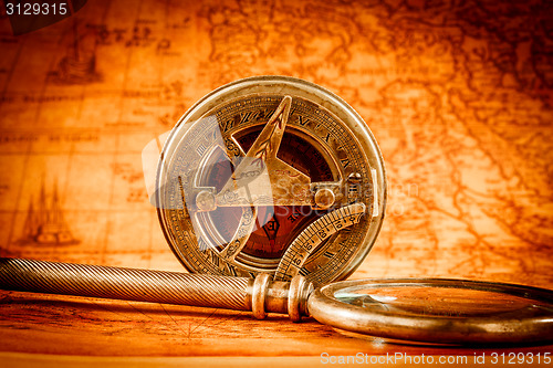 Image of Vintage magnifying glass lies on an ancient world map