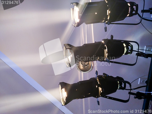 Image of multiple spotlights on a theatre stage lighting rig