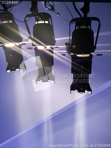 Image of multiple spotlights on a theatre stage lighting rig