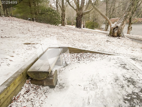 Image of bench in Park in winter with snow 
