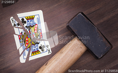 Image of Hammer with a broken card, king of clubs