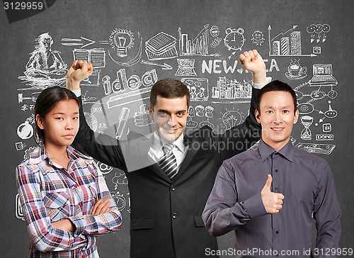 Image of Asian team and businessman with hands up