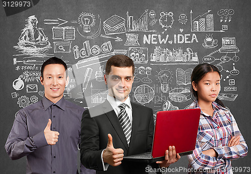 Image of Asian team and male in suit with laptop in his hands