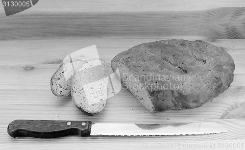 Image of Bread knife with slices of bread cut from a loaf