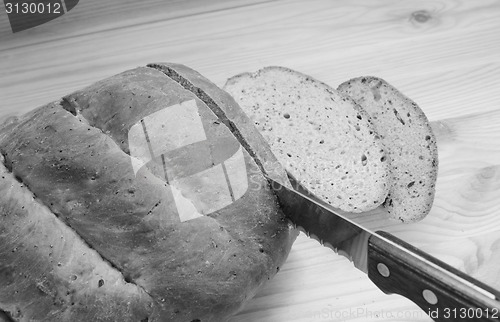 Image of Cutting slices of bread on a wooden table