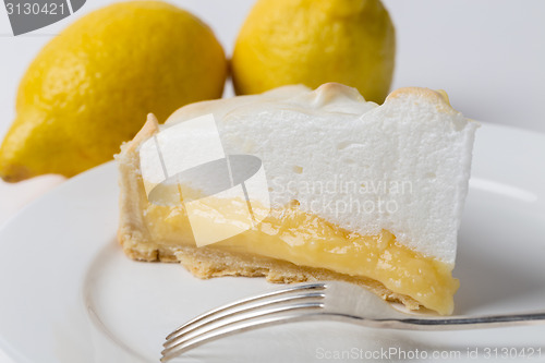 Image of Lemon meringe pie slice with fork and lemons
