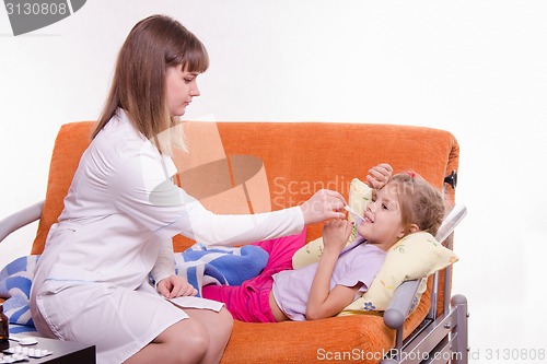 Image of doctor measures temperature the sick girl at home