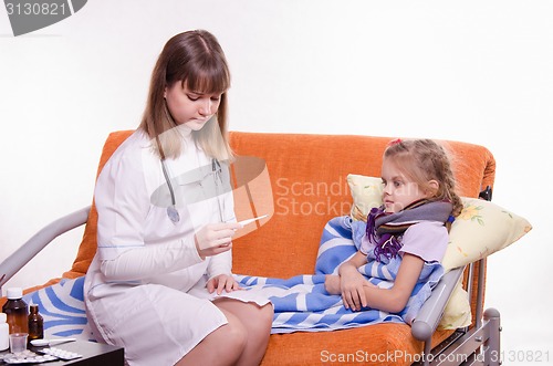 Image of Doctor looking baby temperature on a thermometer