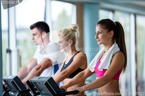 Image of friends  exercising on a treadmill at the bright modern gym