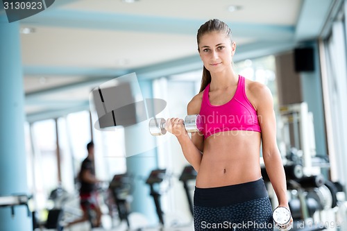 Image of lifting some weights and working on her biceps in a gym