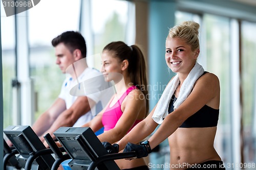 Image of friends  exercising on a treadmill at the bright modern gym