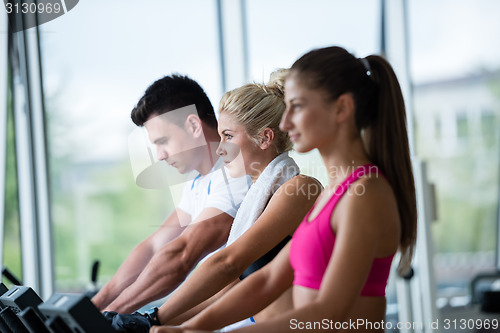 Image of friends  exercising on a treadmill at the bright modern gym