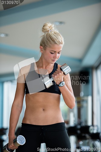 Image of lifting some weights and working on her biceps in a gym