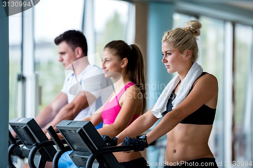 Image of friends  exercising on a treadmill at the bright modern gym