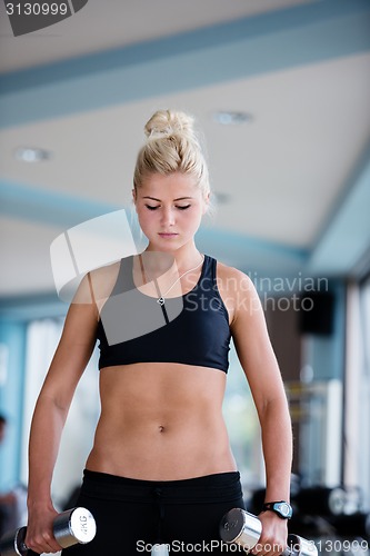 Image of lifting some weights and working on her biceps in a gym